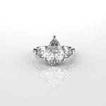Pear shaped centre with trillion side diamonds ring with a star-shaped prong setting on a white background