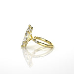 18k yellow gold ring with a large diamond and smaller diamonds set on the hidden halo on the band against a white background