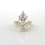 Gold ring with a marquise-shaped diamond with 6 claws on a white background