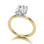 Gold ring with an oval diamond on a white background