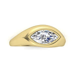 Gold ring with a marquise shaped diamond in rub over setting on a white background