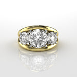 18k yellow gold ring with three round brilliant cut diamonds in claw setting with double bar style ring on a reflective surface